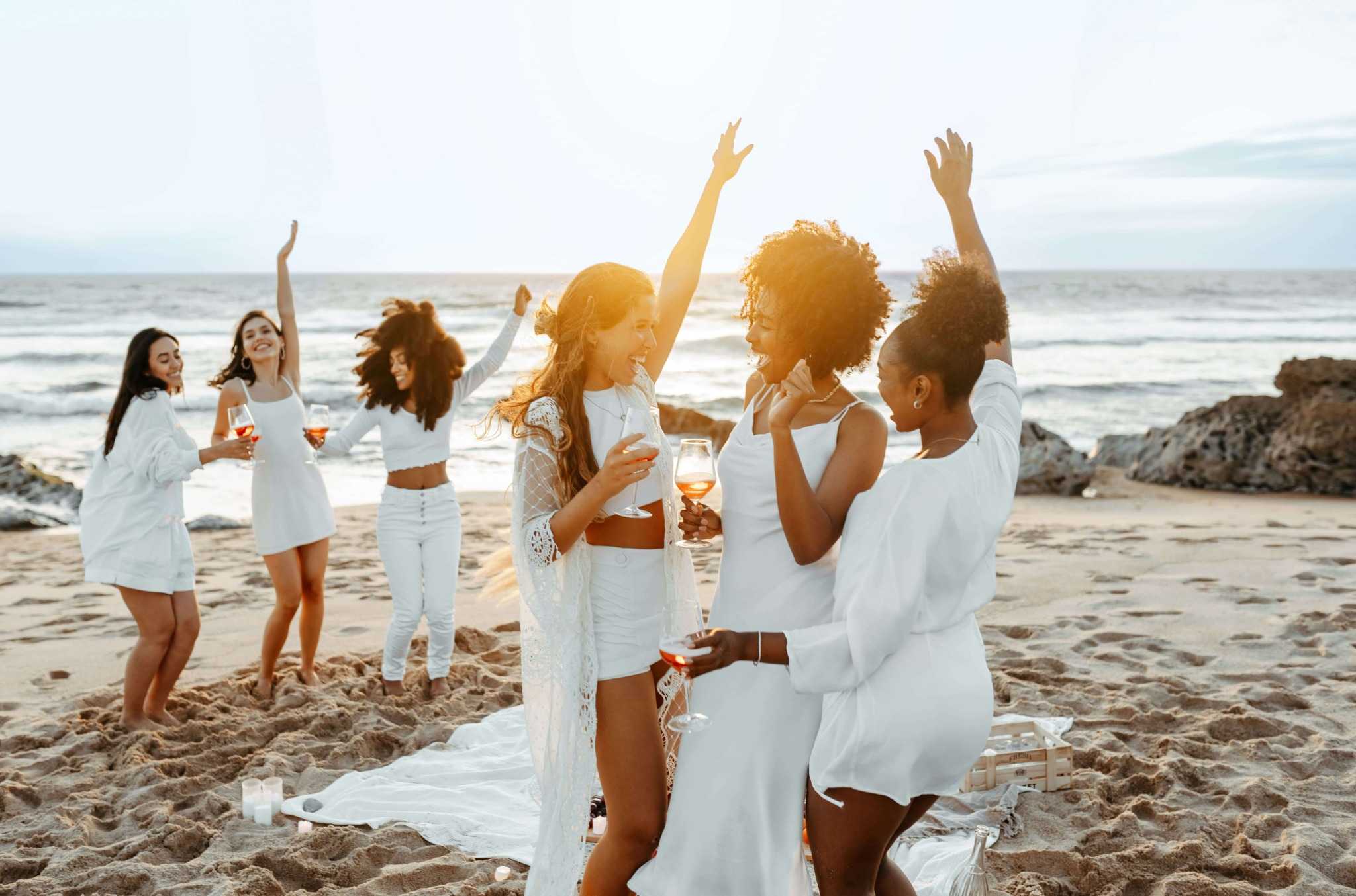 beautiful women dancing by the beach drinking wearing white mallorca retreat