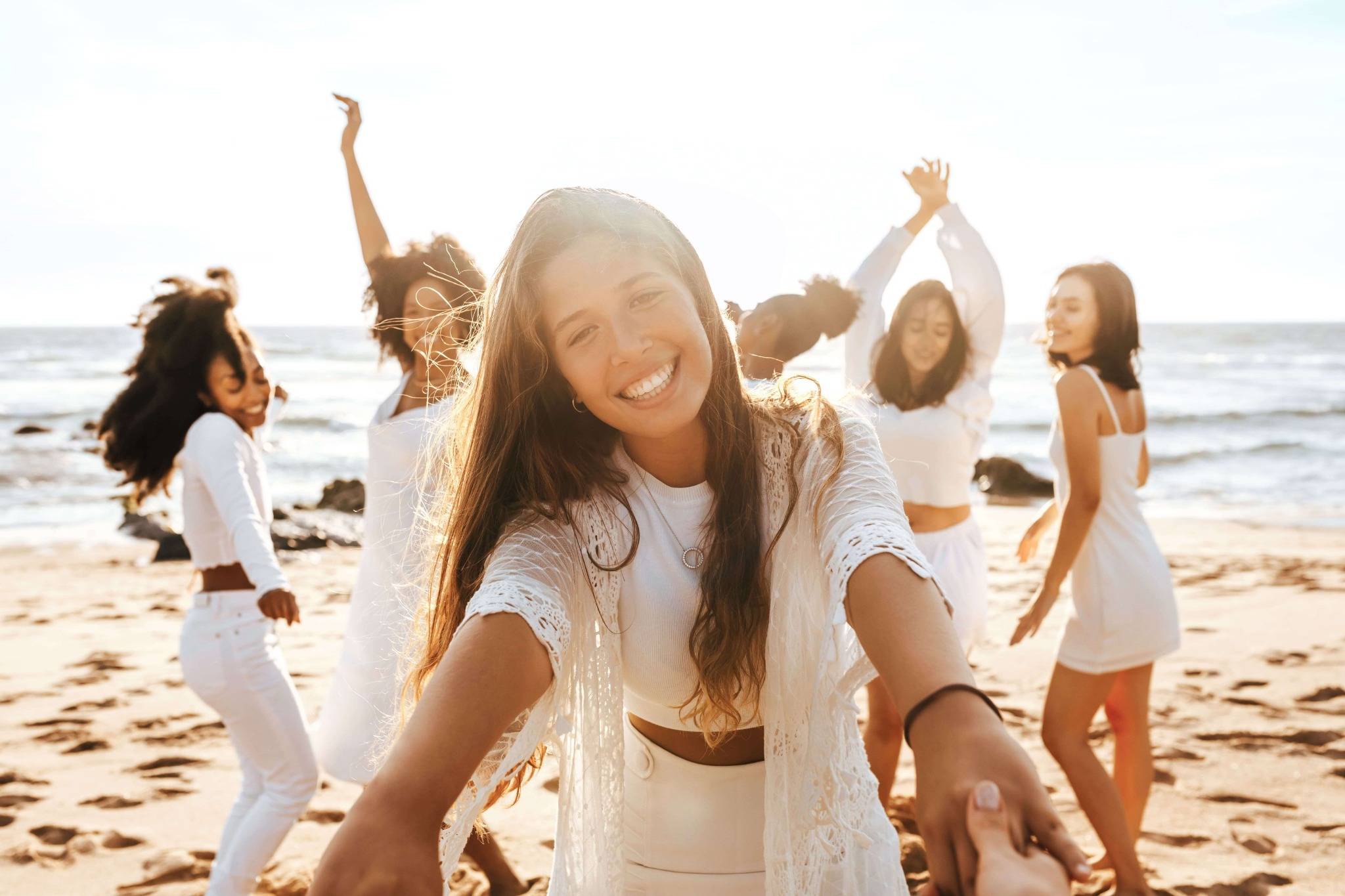 beautiful women dancing by the beach wearing white mallorca retreat